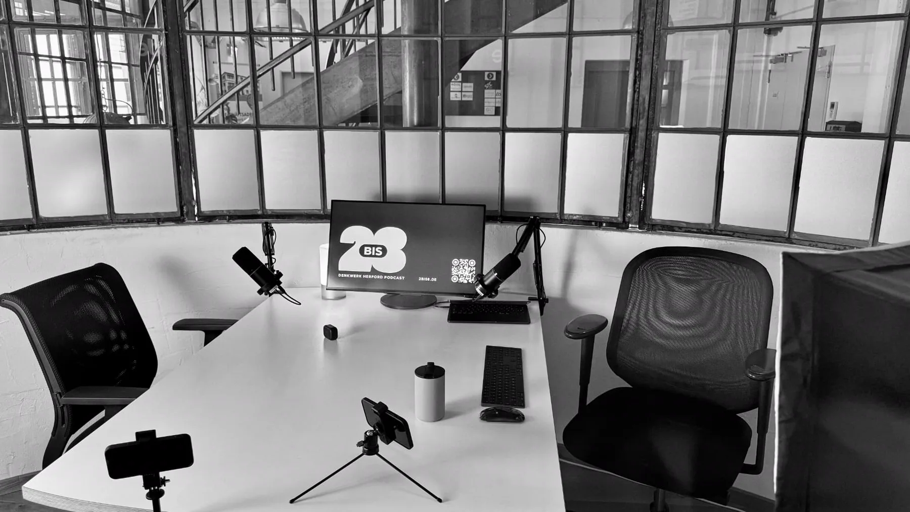 Kompletter Studioaufbau mit Mikrofonen, Monitor und Stühlen