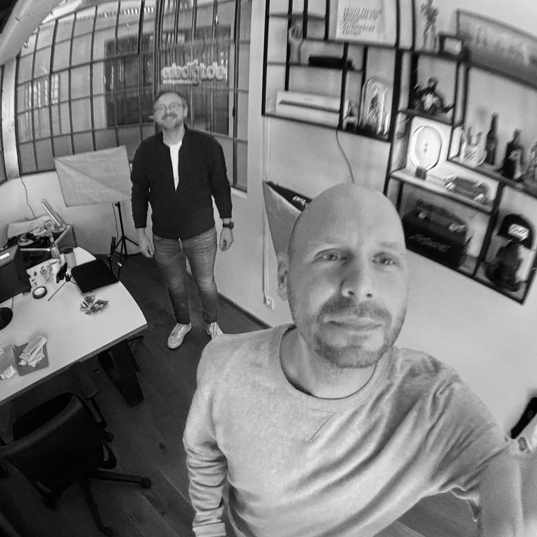 Olli vom Podcast-Studio 2bis8 neben dem Poster „Labern kann jeder. Aufnehmen nicht.“